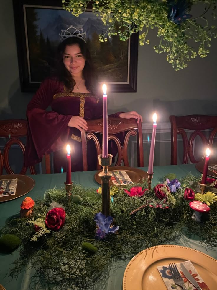 a woman sitting at a table with candles in front of her