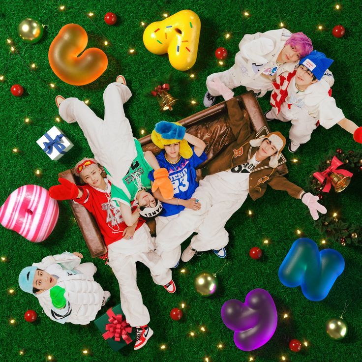 group of people laying on the ground surrounded by balloons