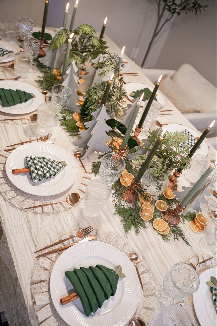 the table is set with white plates and green napkins