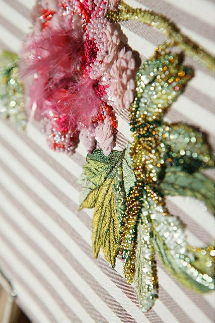 three different colored flowers sitting on top of a striped table cloth covered in sequins