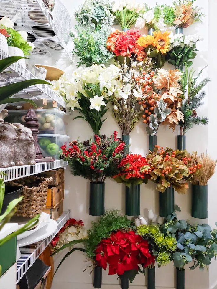 a bunch of flowers are hanging on the wall in a store with shelves full of plants