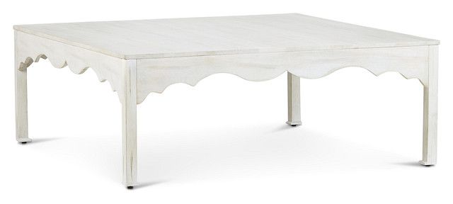 a small white table with scalloped edges on the top and one drawer at the bottom