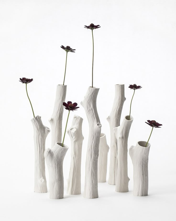 four white vases with flowers in them