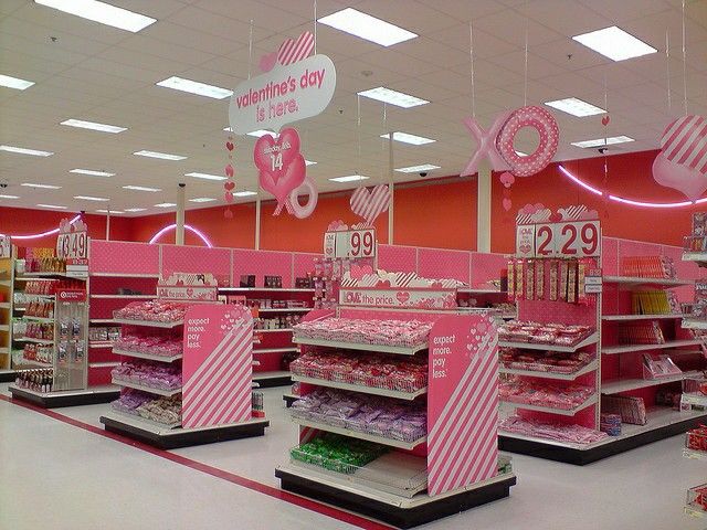 a store with pink and white items for sale in the aisles, including signs that say valentine's day