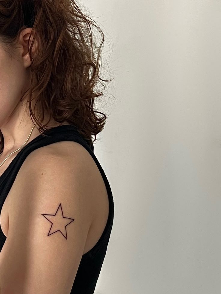 a woman with a small star tattoo on her left upper arm and right lower arm