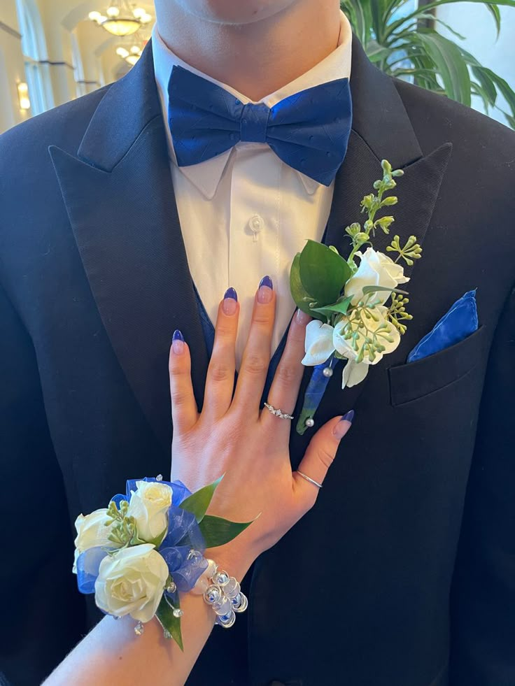 a man in a tuxedo with flowers on his lapel and two rings