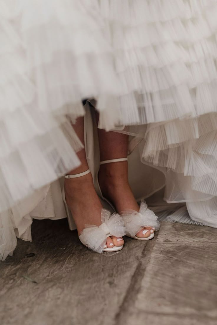 the bride's shoes are all white and have ruffles on them,