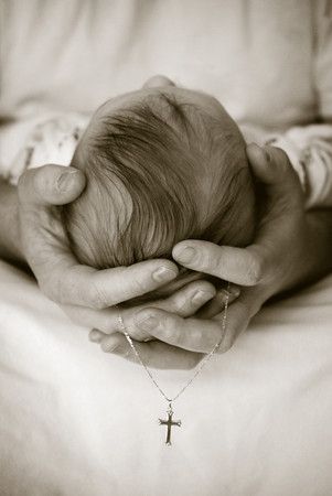 a person holding a baby in their arms with a cross on it's chest