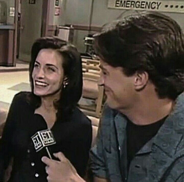 a man and woman sitting next to each other in front of a tv screen talking