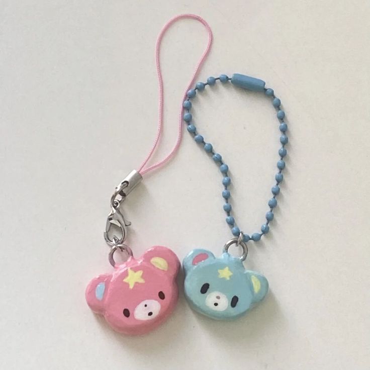 two cute little bears are attached to a lanyard necklace, one is pink and the other is blue