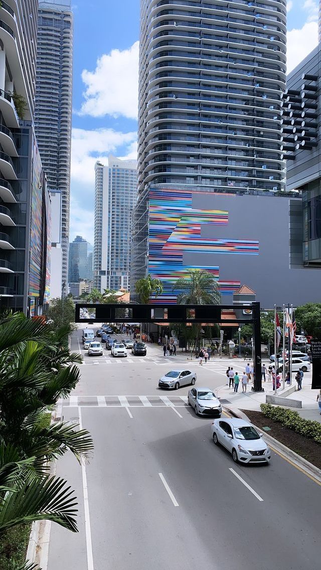 cars are driving down the street in front of tall buildings and high rise skyscrapers