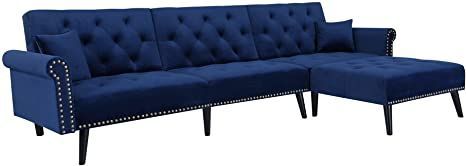 a blue couch and ottoman with studded trim on the back, sitting next to each other