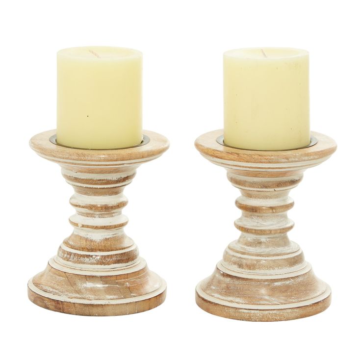 two white candles sitting on top of each other