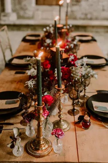 a long table with candles and flowers on it is set up for a formal dinner