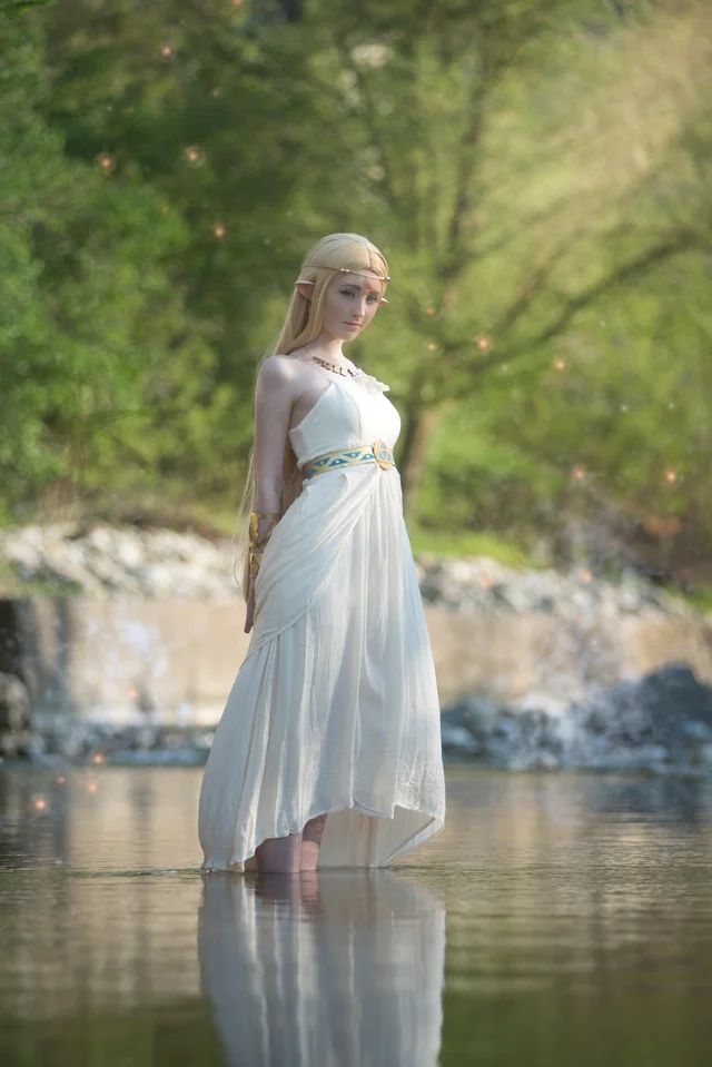 a woman is standing in the water wearing a white dress