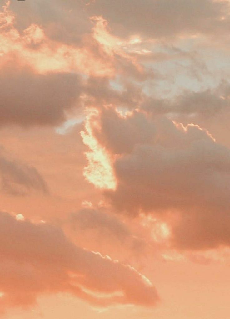 an airplane flying in the sky at sunset