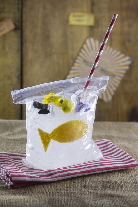 a plastic bag with a straw and some flowers in it