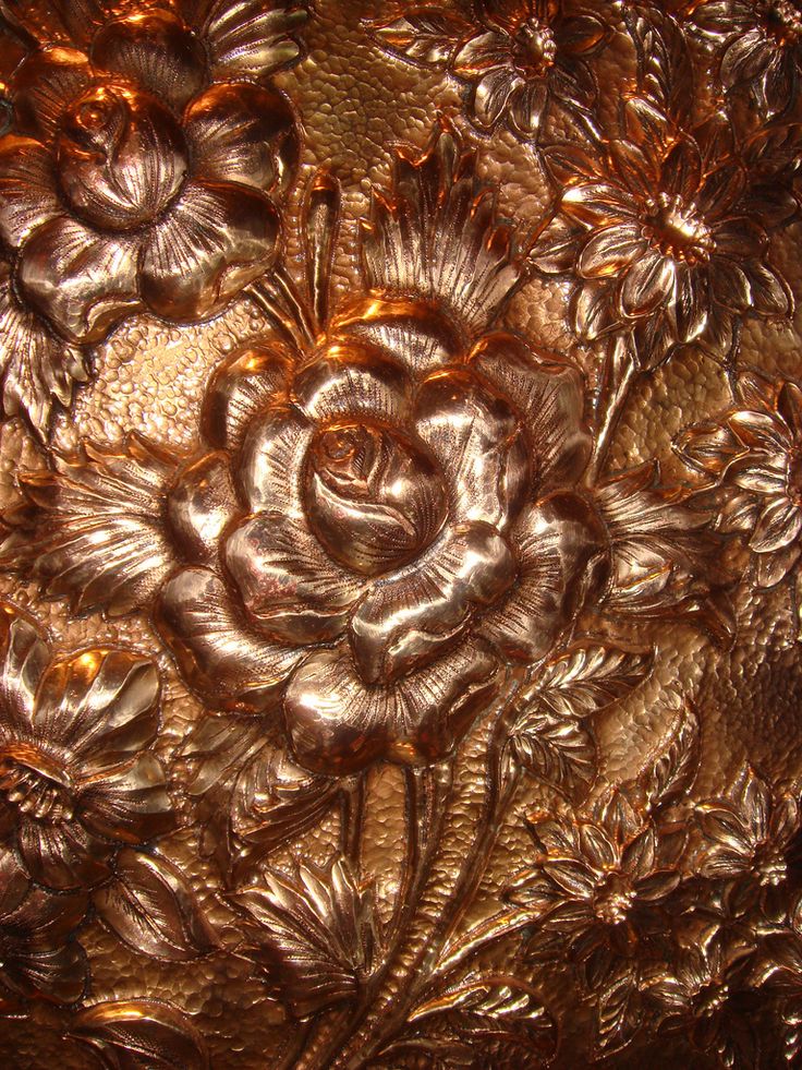 a close up view of an intricately designed piece of metal foil with flowers on it