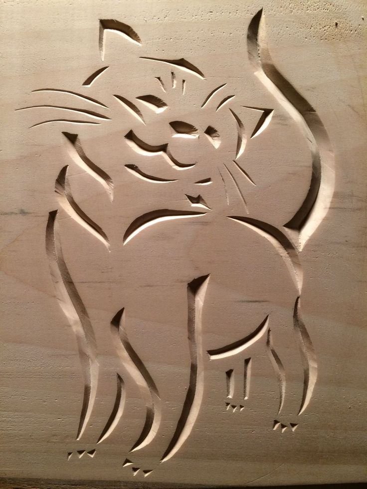 a carved wooden plaque with a cat on it