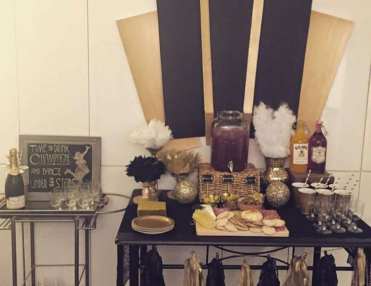 a table topped with lots of different types of food and drinks next to a wall