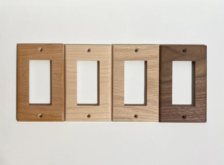 three wooden switch plates mounted to the wall next to each other on a white surface