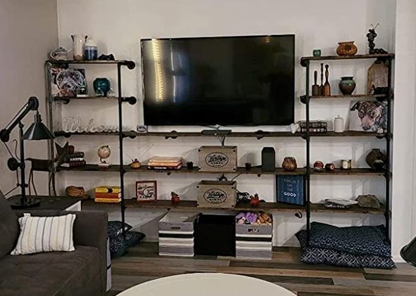 a living room filled with furniture and a large flat screen tv mounted on a wall