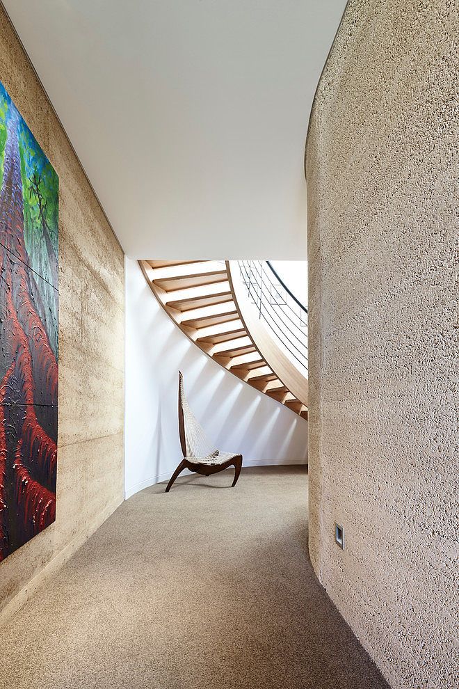 a painting on the wall next to a stair case in a room with carpeted flooring