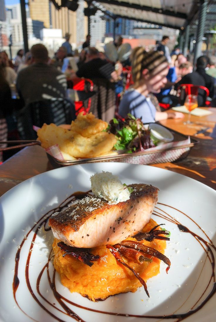 a white plate topped with food on top of a wooden table next to other plates