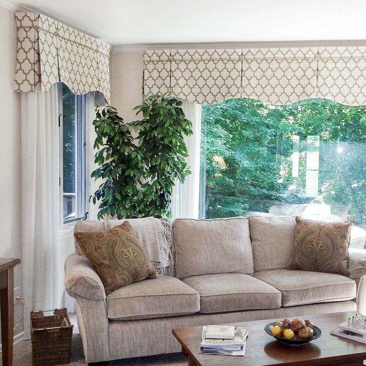 a living room filled with furniture and a window covered in green trees behind the couch