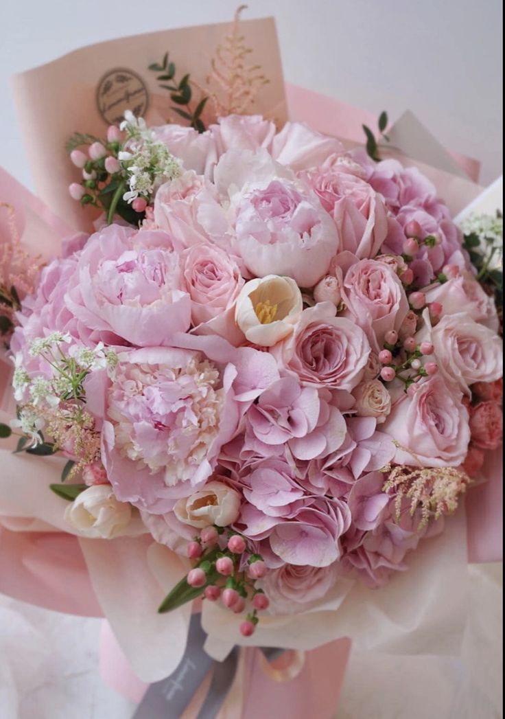 a bouquet of pink flowers sitting on top of a table