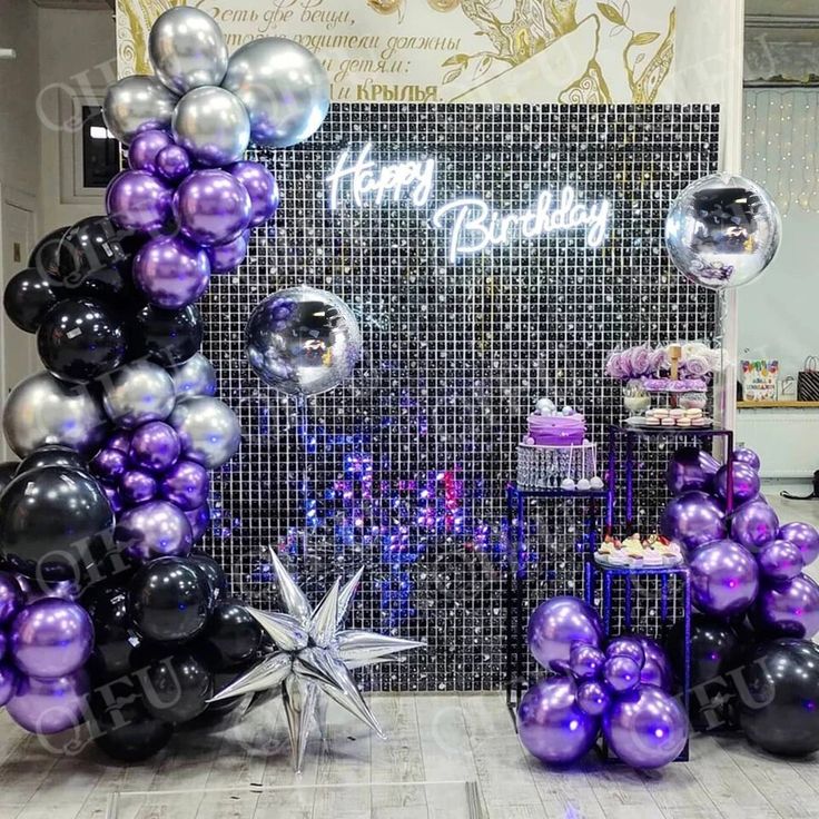 purple and black balloons are on display at a birthday party