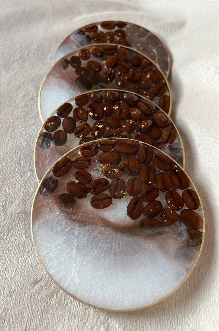 three plates with coffee beans on them sitting on a table