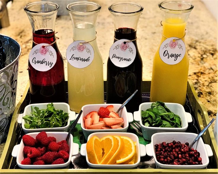 fruit, vegetables and juices are arranged on a tray