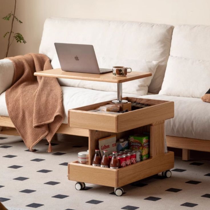 a living room with a couch, coffee table and laptop computer on the end shelf