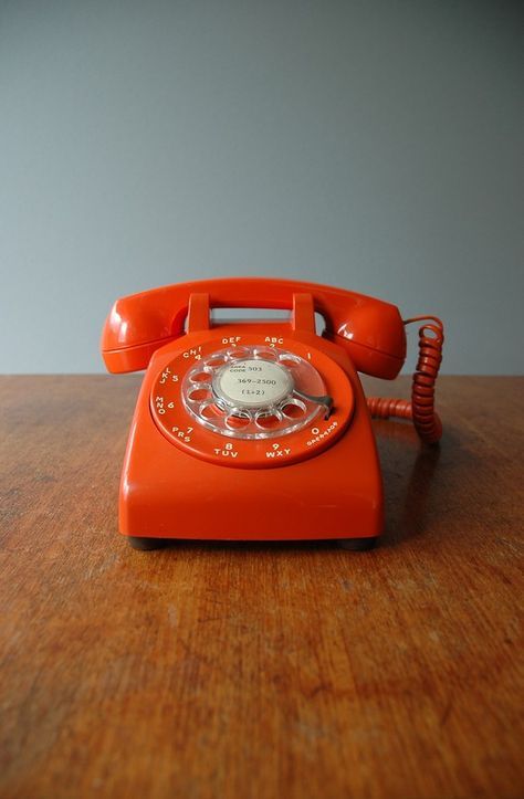 an orange phone sitting on top of a wooden table