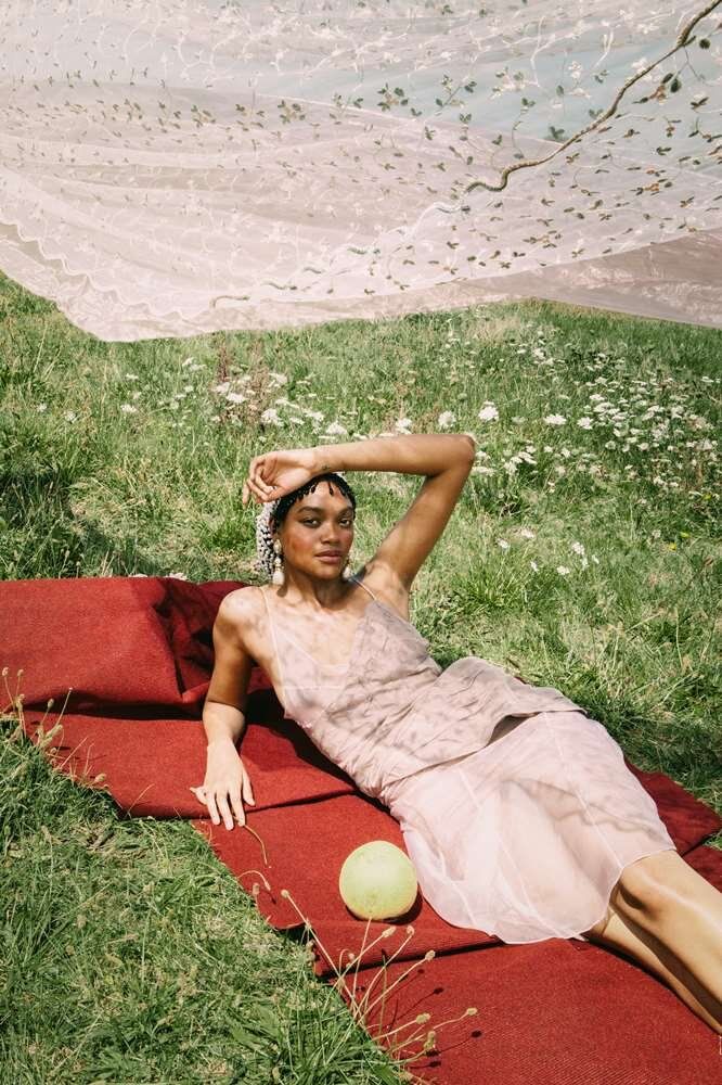 a woman laying on top of a red blanket