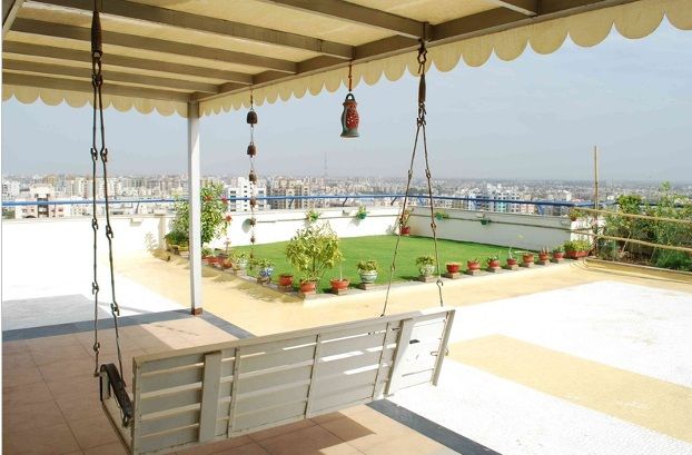 a white bench sitting under a canopy on top of a roof