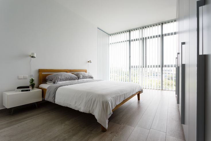 a bedroom with white walls and wood flooring