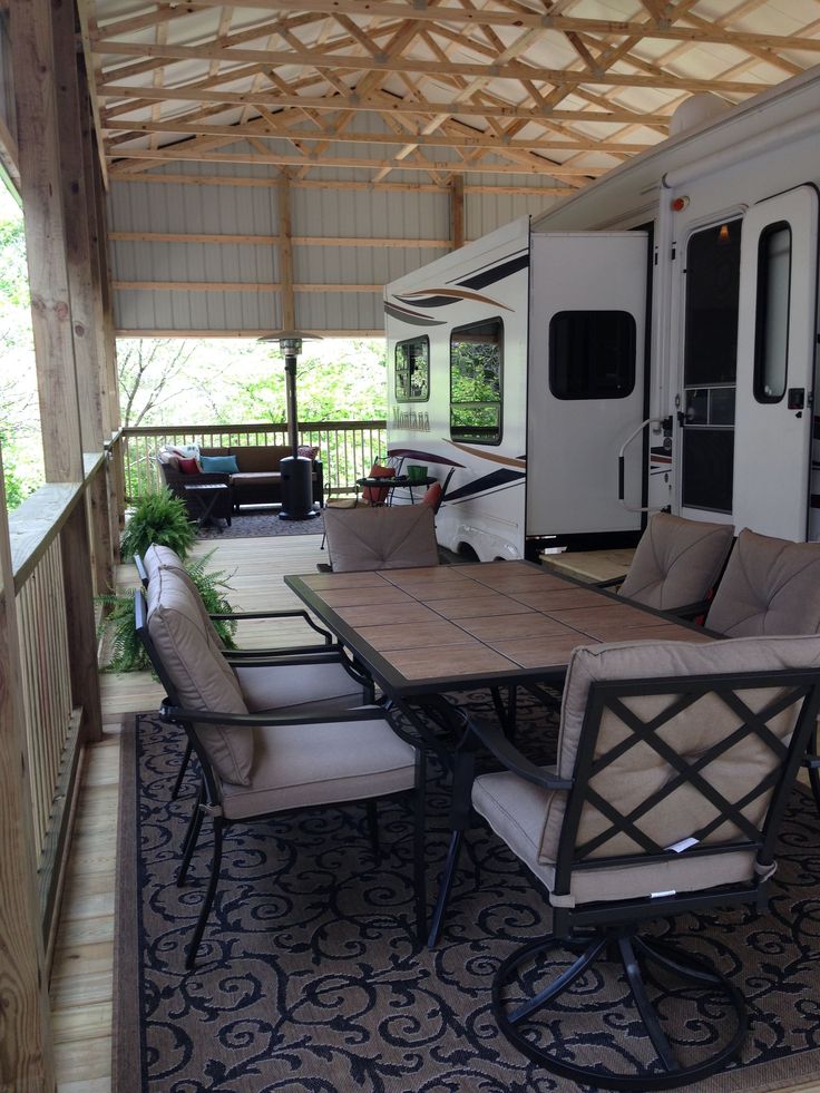 a table and chairs in front of an rv on a patio with wood flooring