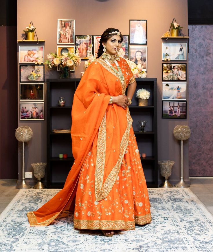 The attractive orange color with all-over gold embroidery in the floral jaal is enough to fetch all the eyes. Delicate embroidery is done with cutdana, sequins and zari with light pink resham and mint color flowers. The classic silhouette adds to the royalty of this lehenga. This lehenga is perfect for the anytime occasions. You have the option to change the color of the garment and make it according to your requirements. Please contact our Sales Team through WhatsApp +61470219564 to discuss you Orange Cutdana Sharara With Traditional Drape, Orange Sharara With Cutdana For Diwali, Orange Cutdana Sharara For Diwali, Orange Anarkali Set With Zari Work Traditional Drape, Anarkali Orange Sharara With Zari Work, Traditional Orange Anarkali Set With Gota Work, Orange Sharara With Dupatta In Traditional Drape, Orange Sharara With Resham Embroidery In Traditional Drape, Orange Sharara With Resham Embroidery For Navratri