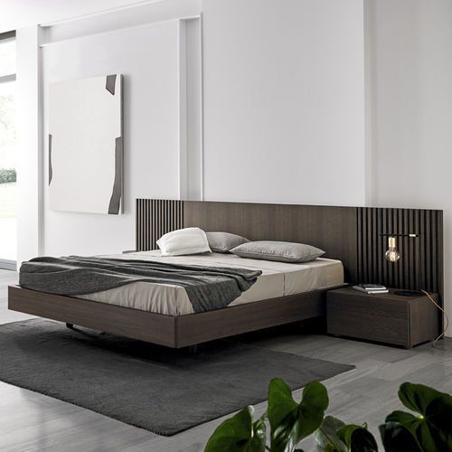 a modern bedroom with grey walls and wooden furniture