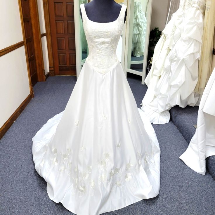 a white wedding dress on display in a bridal room