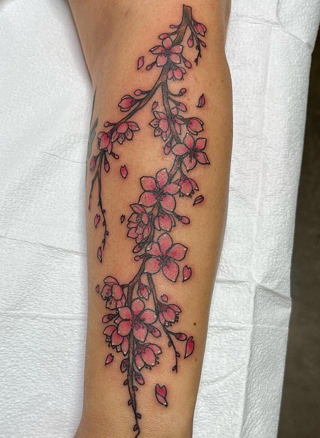 a woman's arm with pink flowers on it