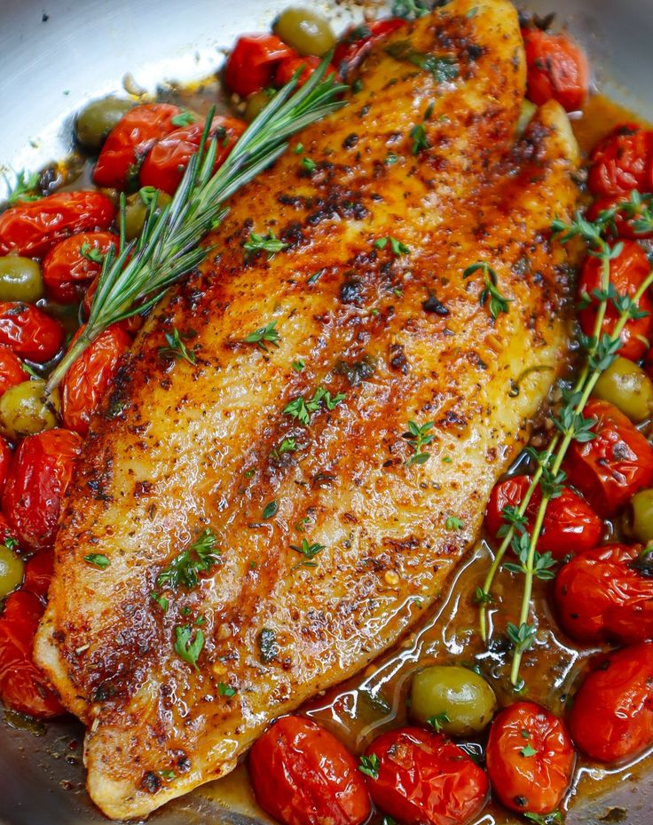 chicken with tomatoes and olives in a pan on the stove for garnish