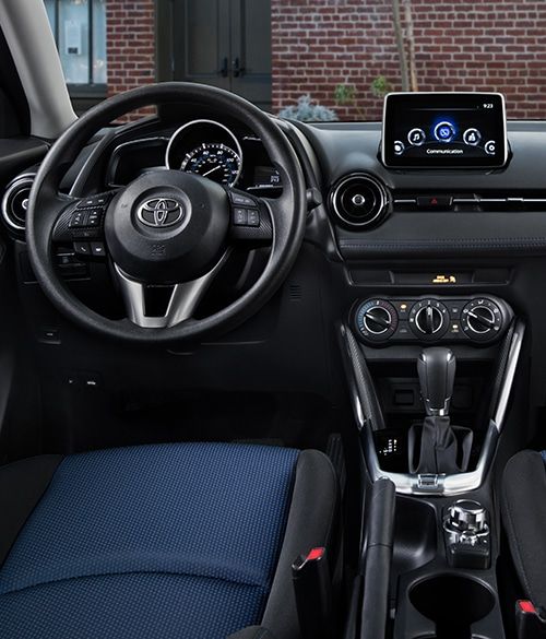 the interior of a car with blue seats and steering wheel, including an electronic display