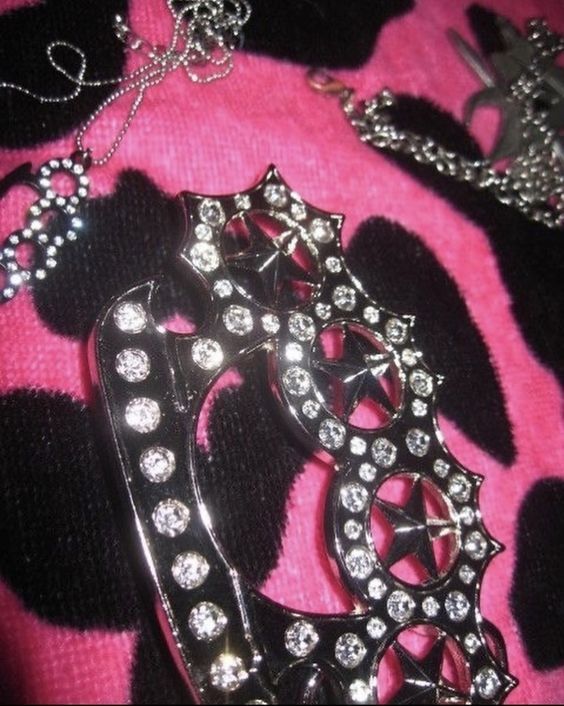 a close up of a brooch on a pink and black blanket with other items