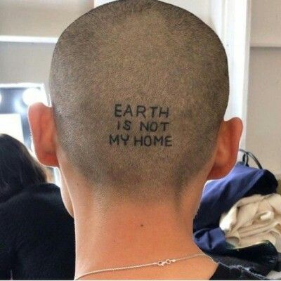 the back of a man's head with words written on it that read earth is not my home