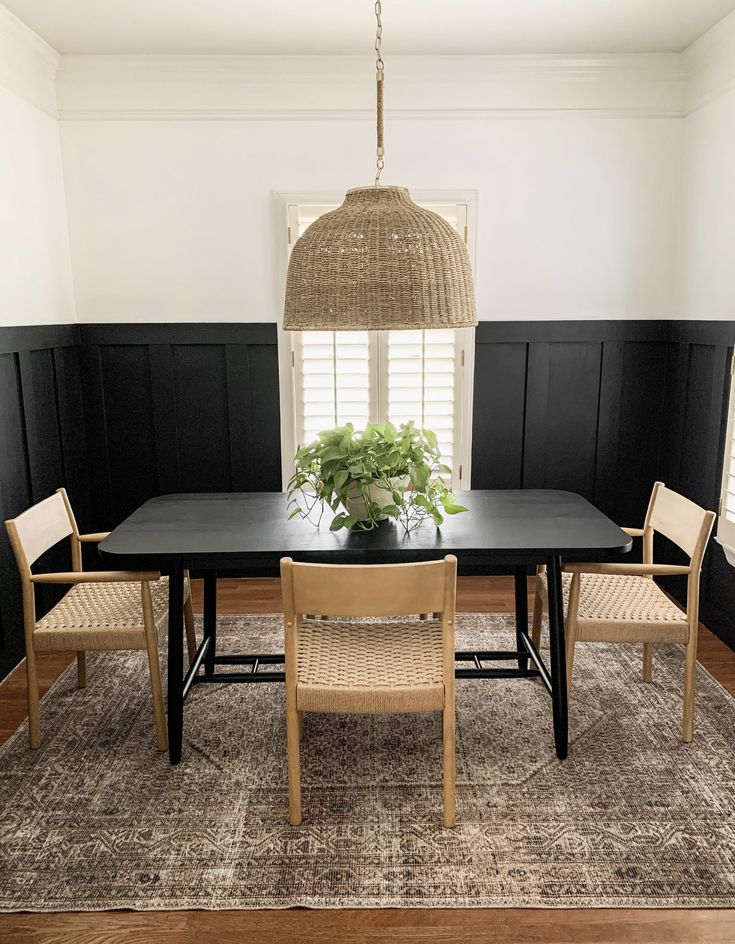 a dining room table with chairs and a potted plant on top of the table