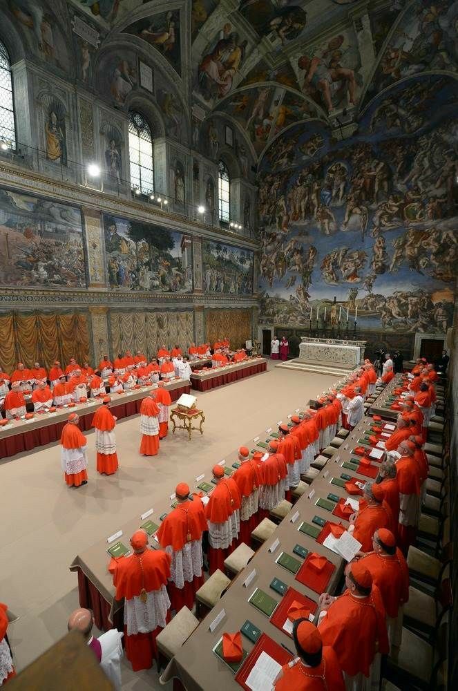 a large room filled with lots of tables covered in red and white cloths next to paintings on the walls