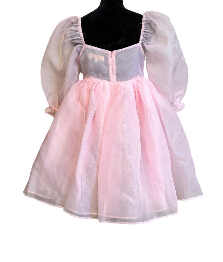 Pink Organza Babydoll Dress This is the babydoll dress for a kind-hearted and adventurous princess. It's made entirely of high quality sheer organza fabric, which makes it the puffiest, most dramatic babydoll dress in all of our collections! The skirt is made of three layers and the body is double layered. All of the seams are inside of the layers to prevent fraying and itchiness. The elastic at the the bottom of the sleeve creates a ruffle effect. It closes at the back with an invisible zipper. Pink Princess Tutu Dress For Evening, Pink Feminine Dress For Costume Party, Feminine Pink Dress For Costume Party, Balletcore Puff Sleeve Party Dress, Pink Fitted Fairy Dress For Fancy Dress, Fitted Organza Tutu Dress For Baptism, Fitted Princess Style Tutu Dress In Organza, Fitted Princess Organza Tutu Dress, Fitted Princess Style Organza Tutu Dress